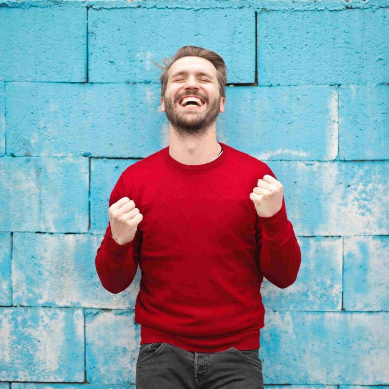Man in red jumper looking happy